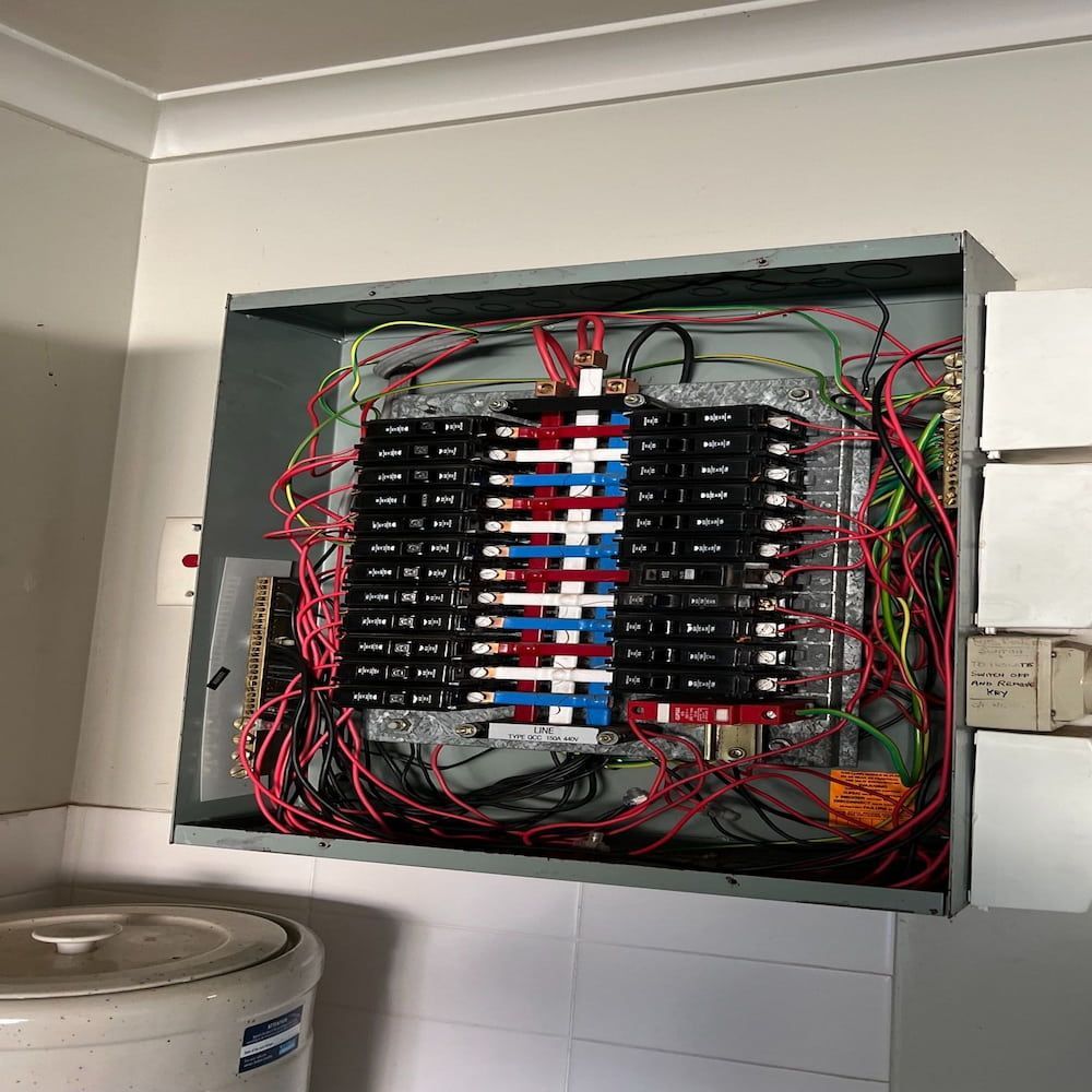 A Very Messy Electrical Box is Hanging on a Wall — Central Electrical Group in Gladstone Central, QLD