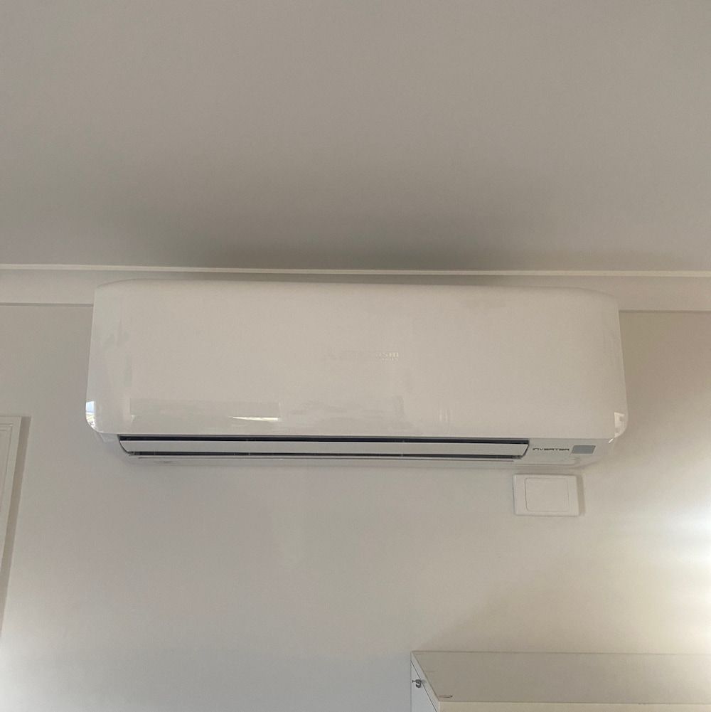 A White Air Conditioner is Hanging From the Ceiling in a Room — Central Electrical Group in Gracemere, QLD