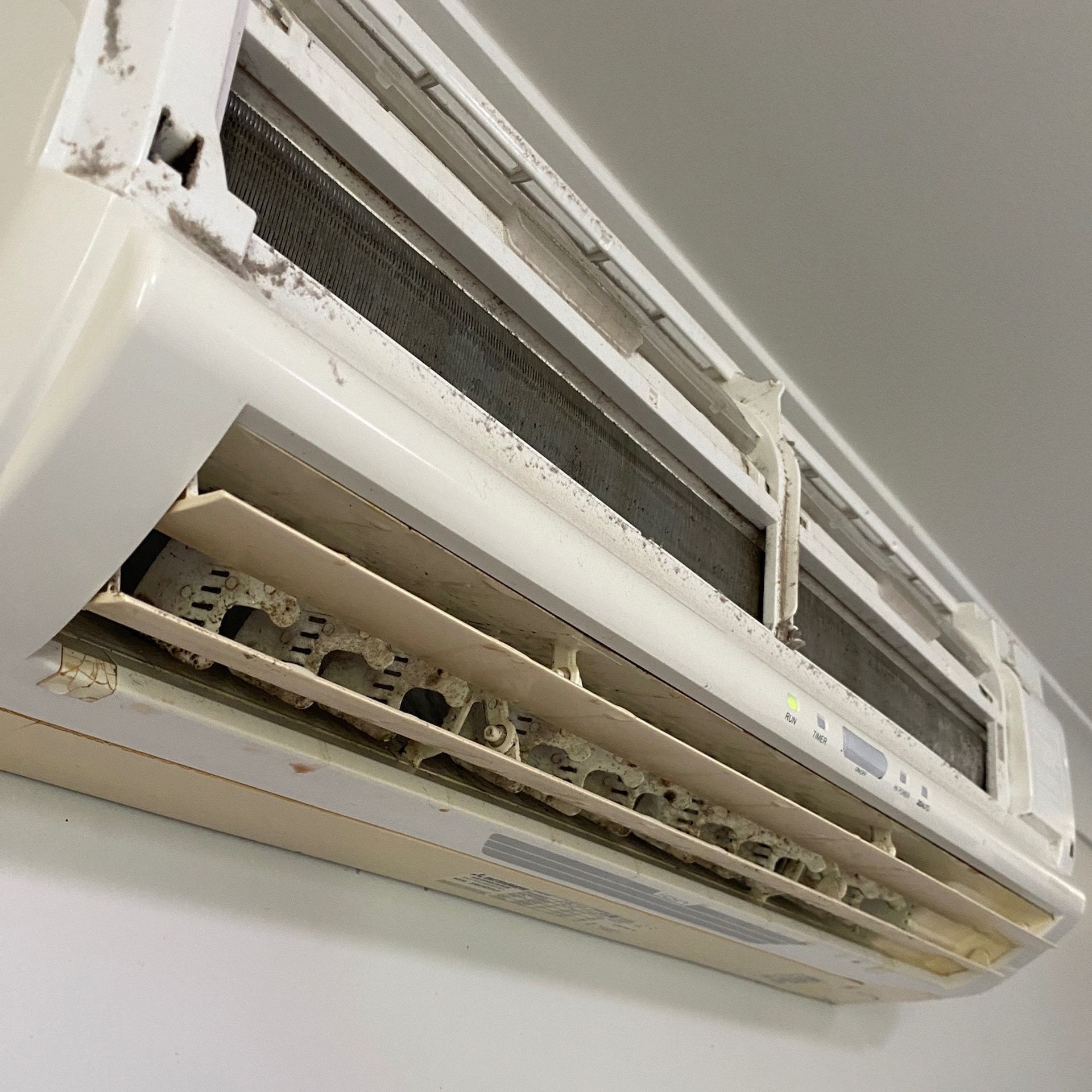 A White Air Conditioner is Hanging on a White Wall — Central Electrical Group in Gladstone Central, QLD