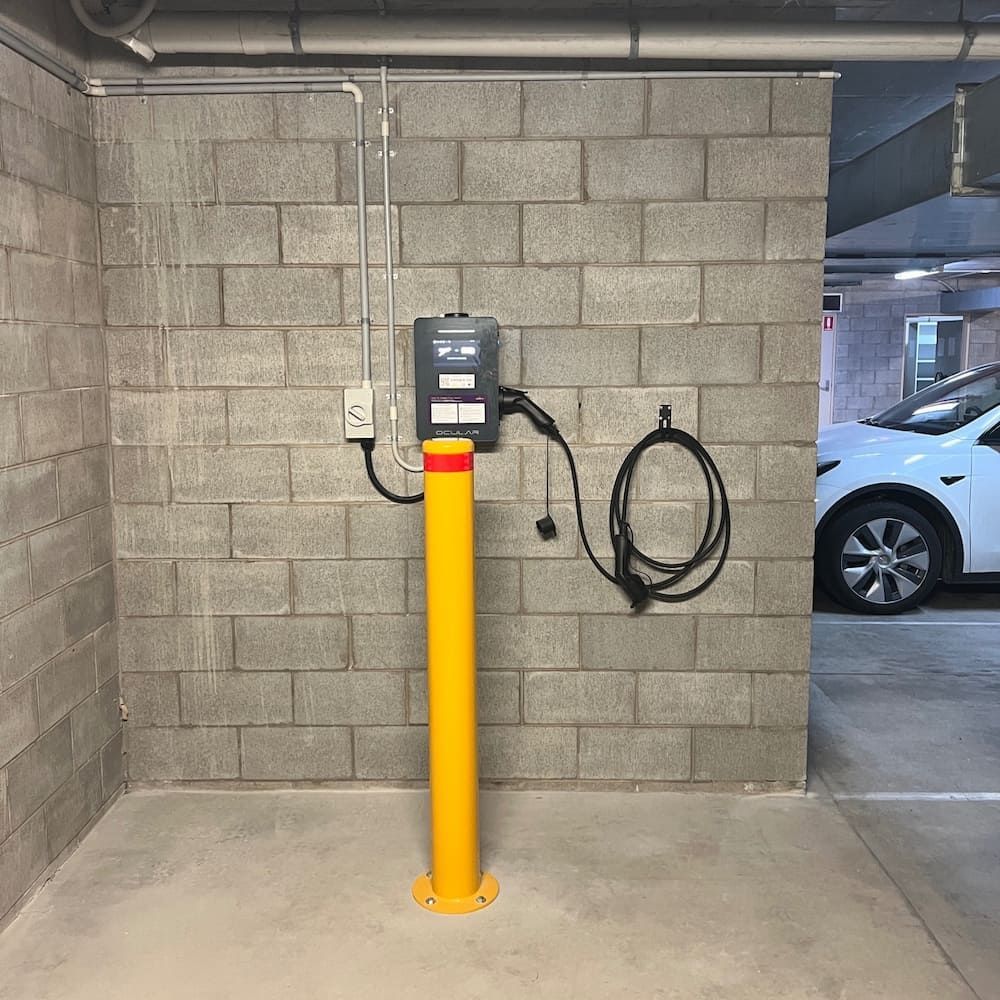 A Yellow Pole With a Charger Attached to It in a Parking Garage — Central Electrical Group in Gladstone Central, QLD