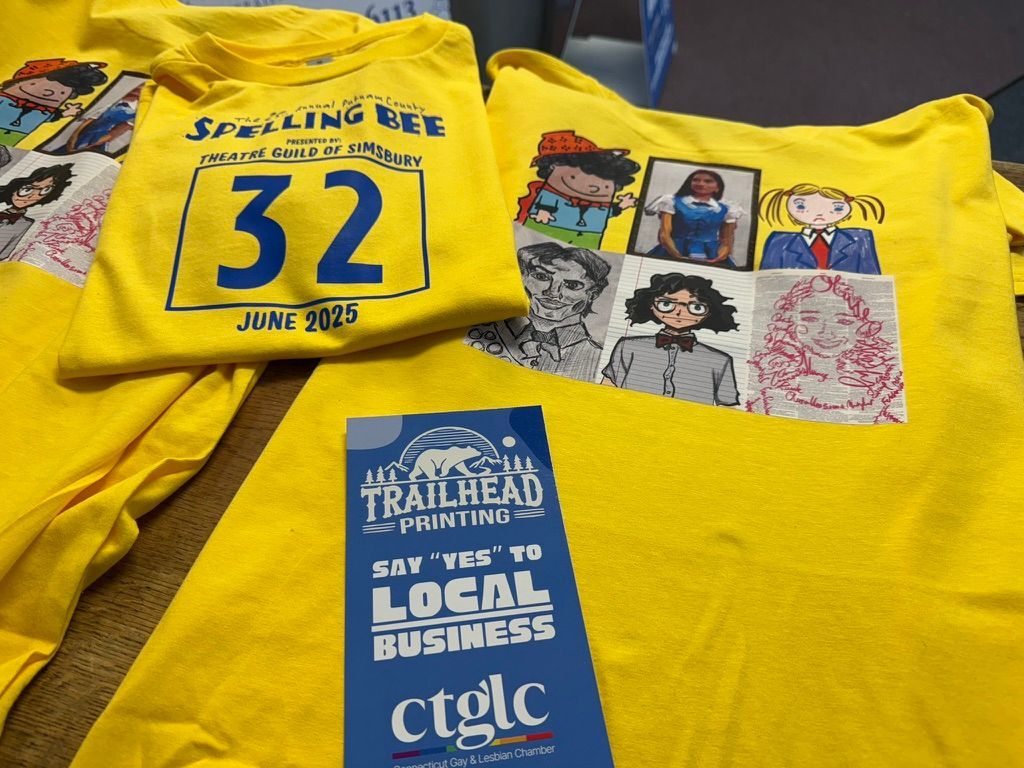 Yellow t-shirts with printed designs and a blue flyer from Trailhead Printing, promoting support for local business.