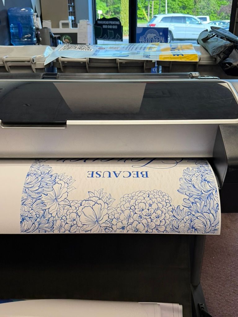 Large-format printer printing a blue and white floral pattern with the word 