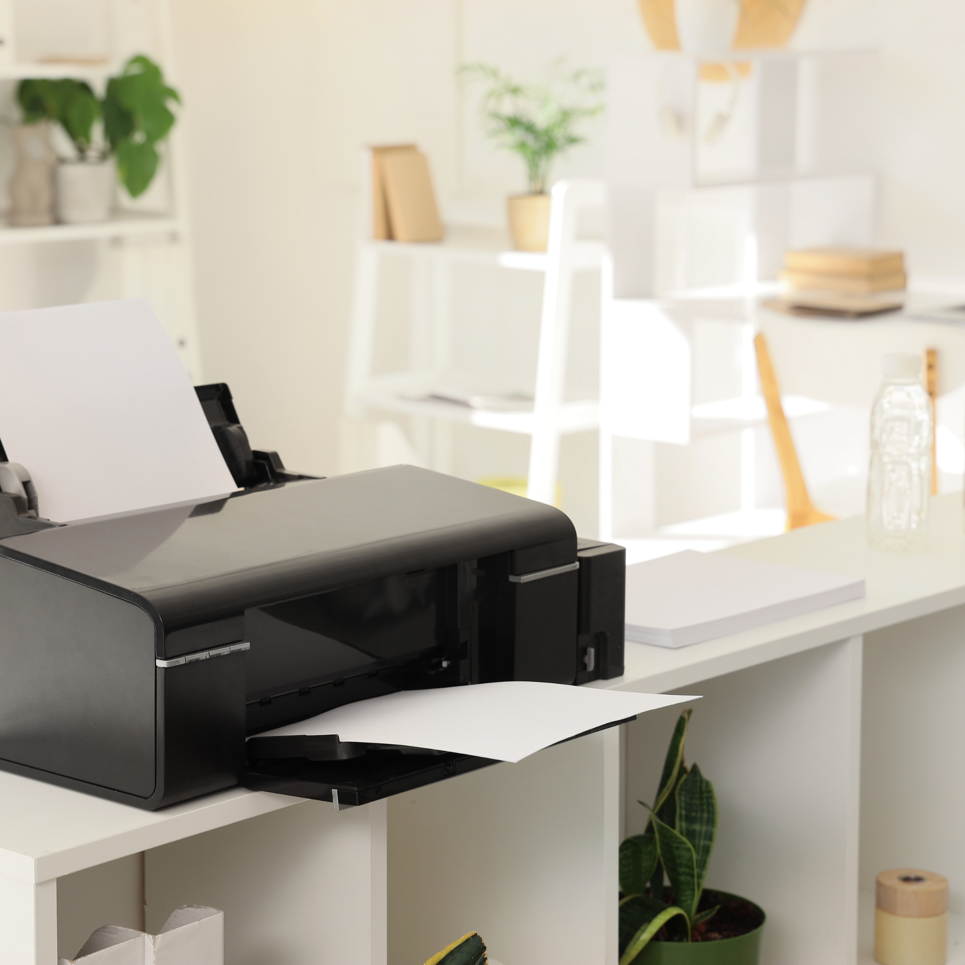 Stack of white envelopes and paper with pens and a ruler on a wooden desk.