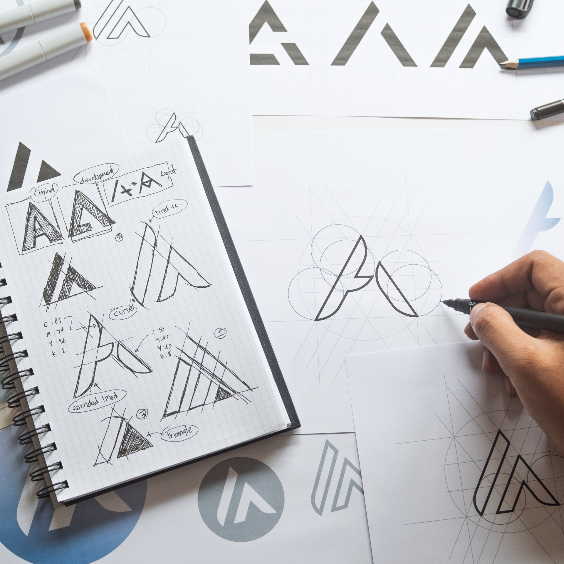 Person sketching logo concepts with 