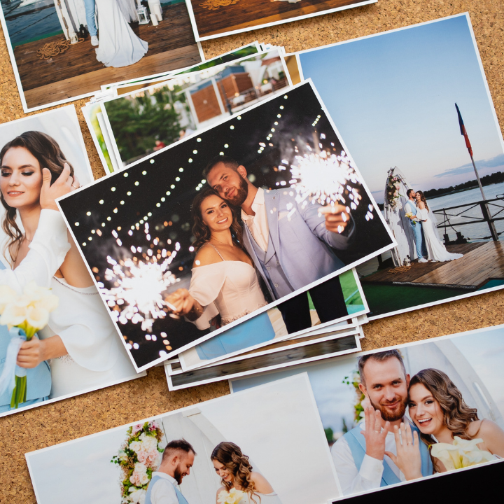 Wedding photos arranged on corkboard: couple smiling with sparklers, bride with bouquet, setting outdoors.