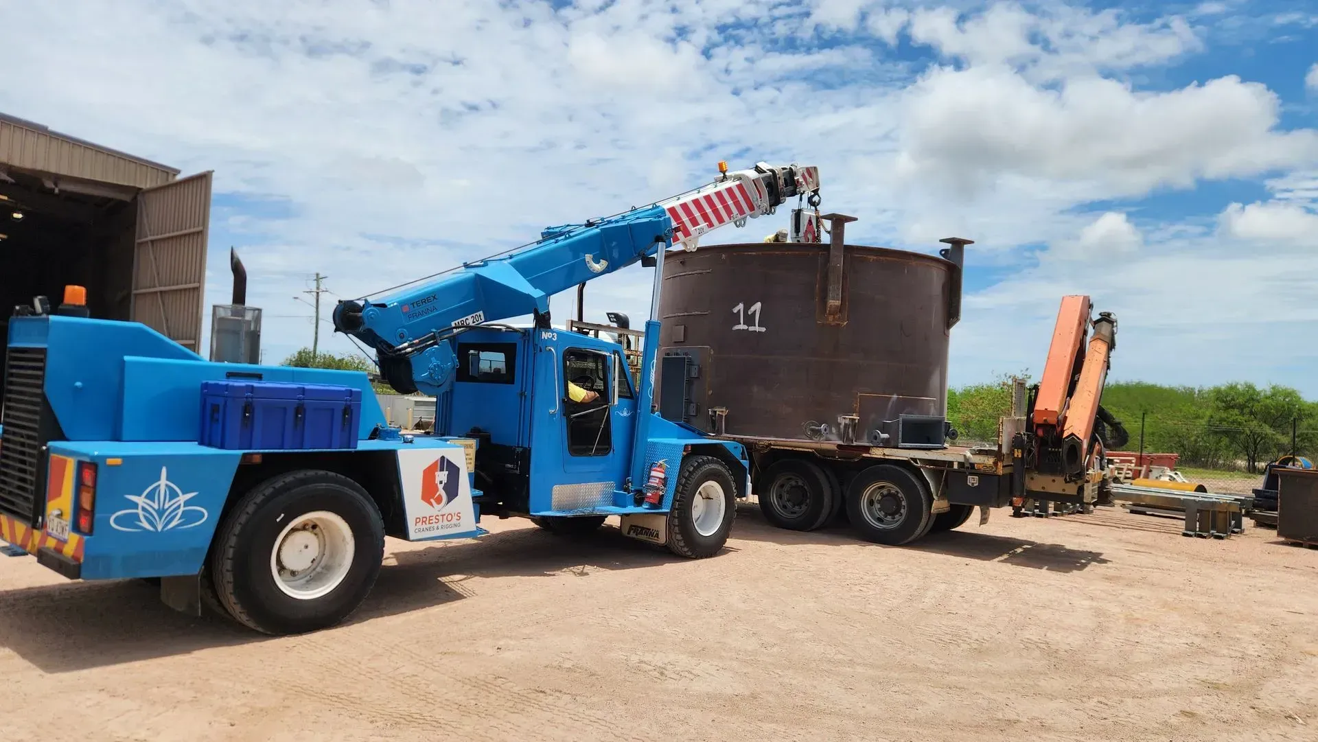 Blue Crane Lifting a Large Metal Tank Onto a Trailer — Presto's Cranes & Rigging NQ in Garbutt, QLD