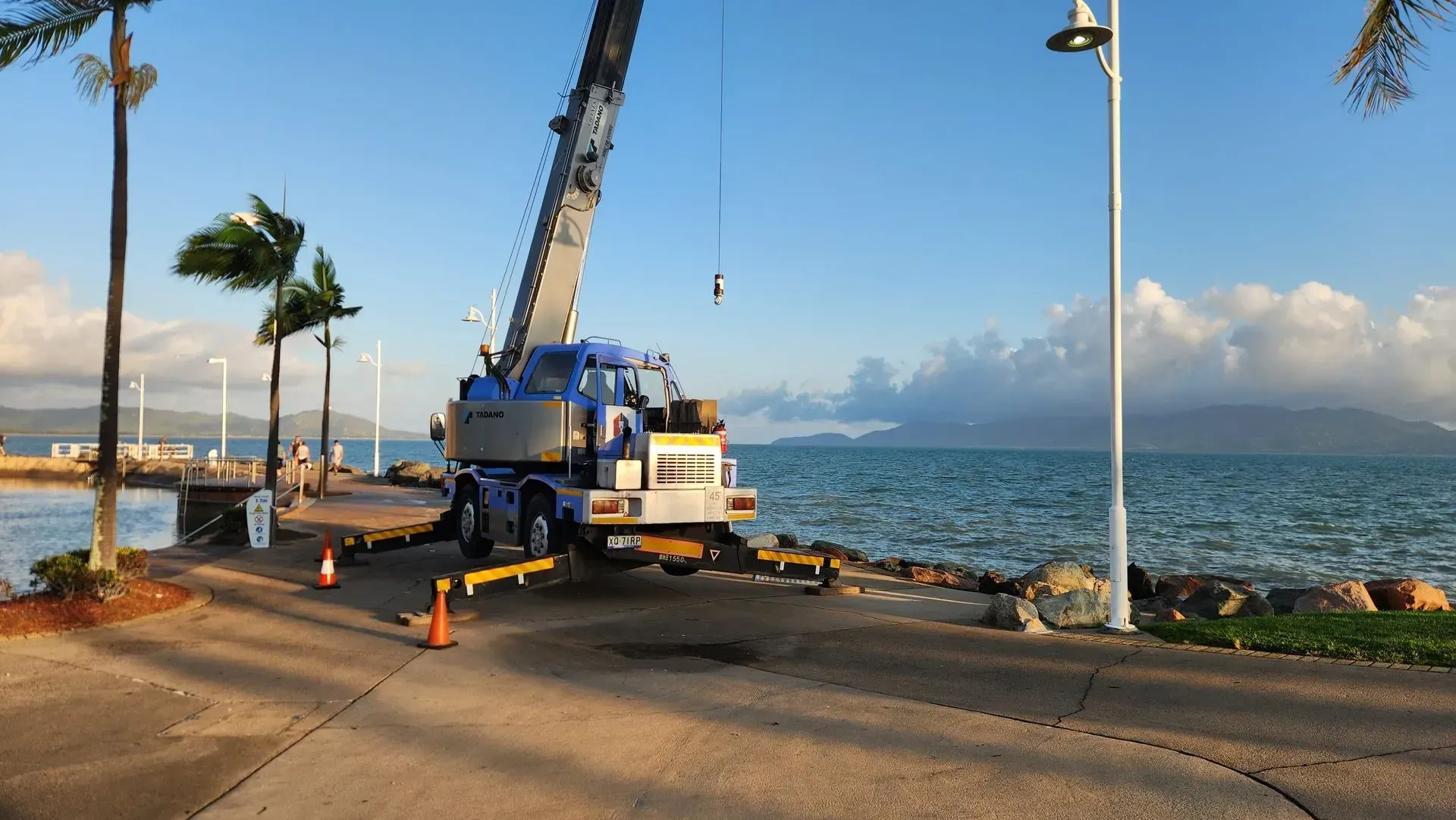 Crane on a Waterfront Lifting Something; Ocean and Mountains in Background — Presto's Cranes & Rigging NQ in Garbutt, QLD