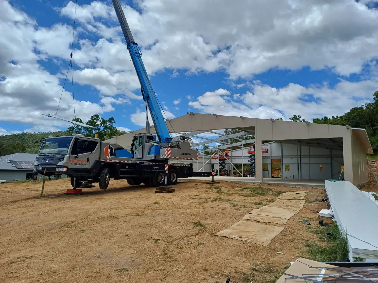 A Crane Lifting a Structural Component Onto a Building Under Construction — Presto's Cranes & Rigging NQ in Garbutt, QLD