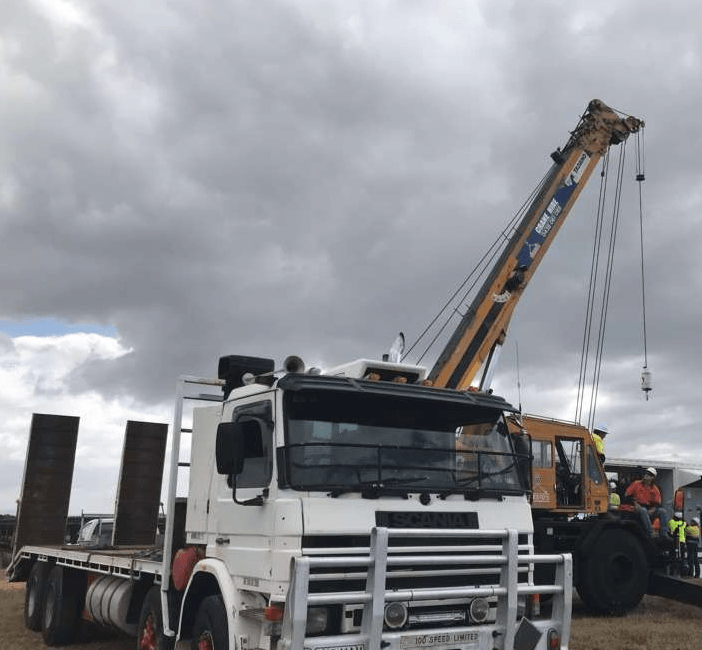 White Truck With a Flatbed Trailer Next — Presto's Cranes & Rigging NQ in Garbutt, QLD