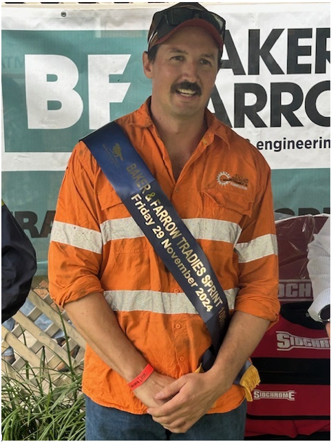 A man wearing an orange shirt and a sash that says bf on it