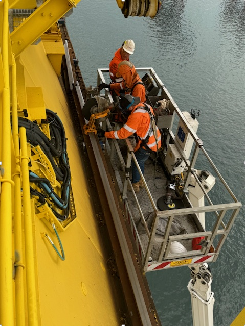 A Couple Of Men Are Working On A Yellow Boat — JMG Maintenance & Fabrication In Muswellbrook NSW
