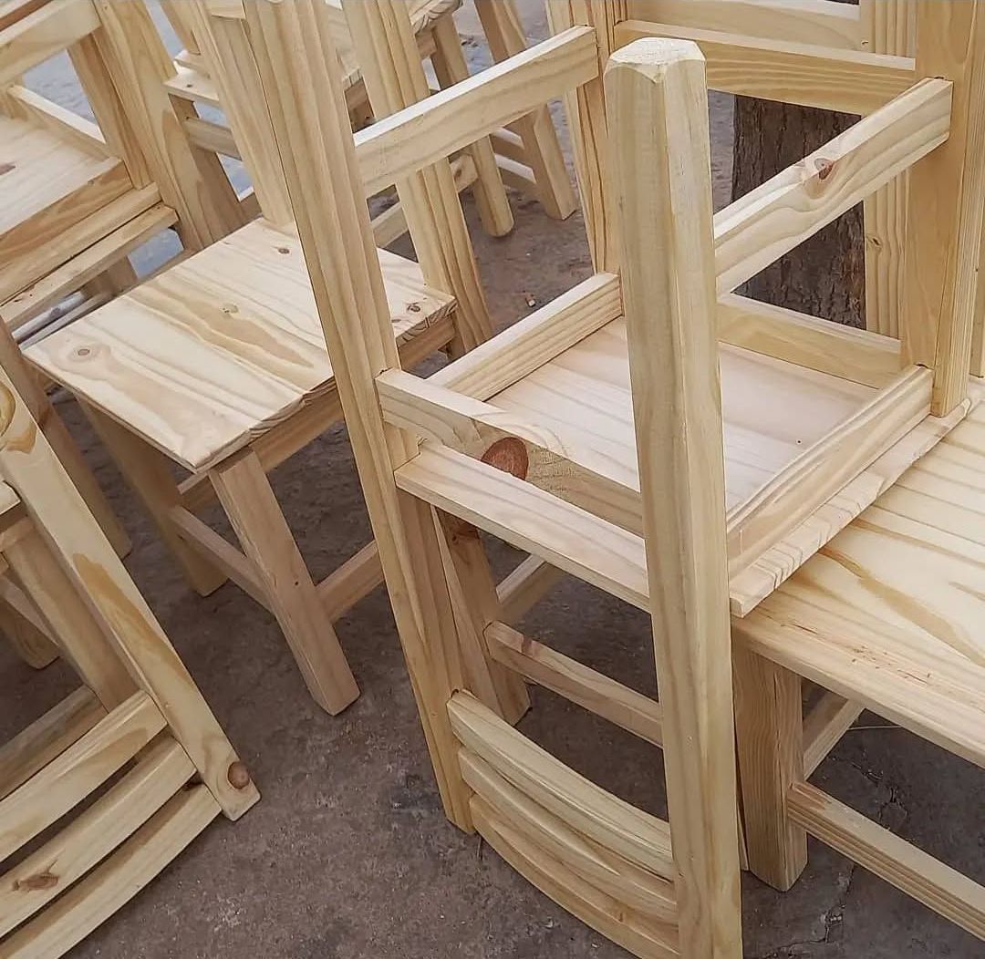 Un montón de sillas de madera están apiladas una encima de otra.