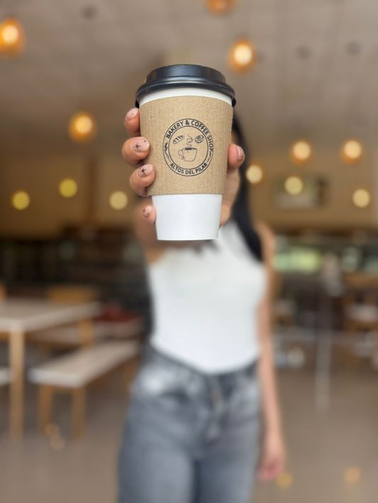 Interior con pared de ladrillo, decoración negra, columnas blancas y arte moderno.