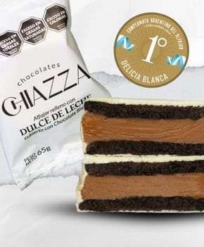 Una barra de chocolate Chiazza rellena de dulce de leche, con el logo de un paquete y un premio. La barra, con capas blancas y marrones, es de chocolate.