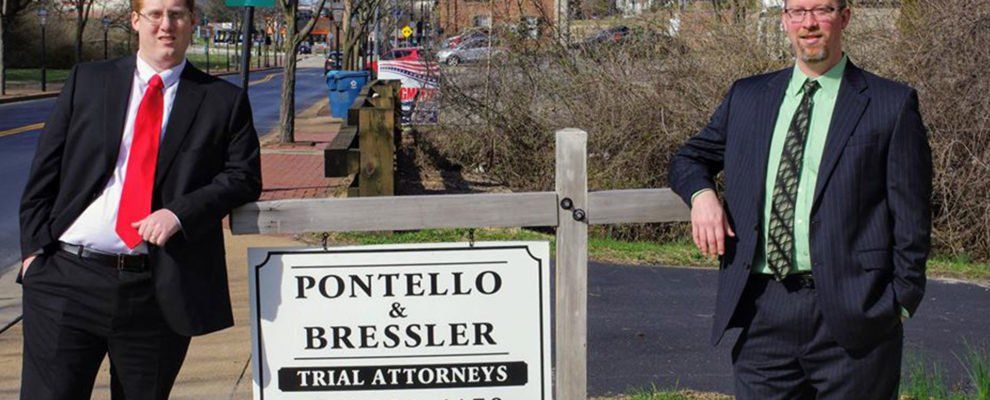 Attorneys Pontello & Bressler pose with their firm's street sign