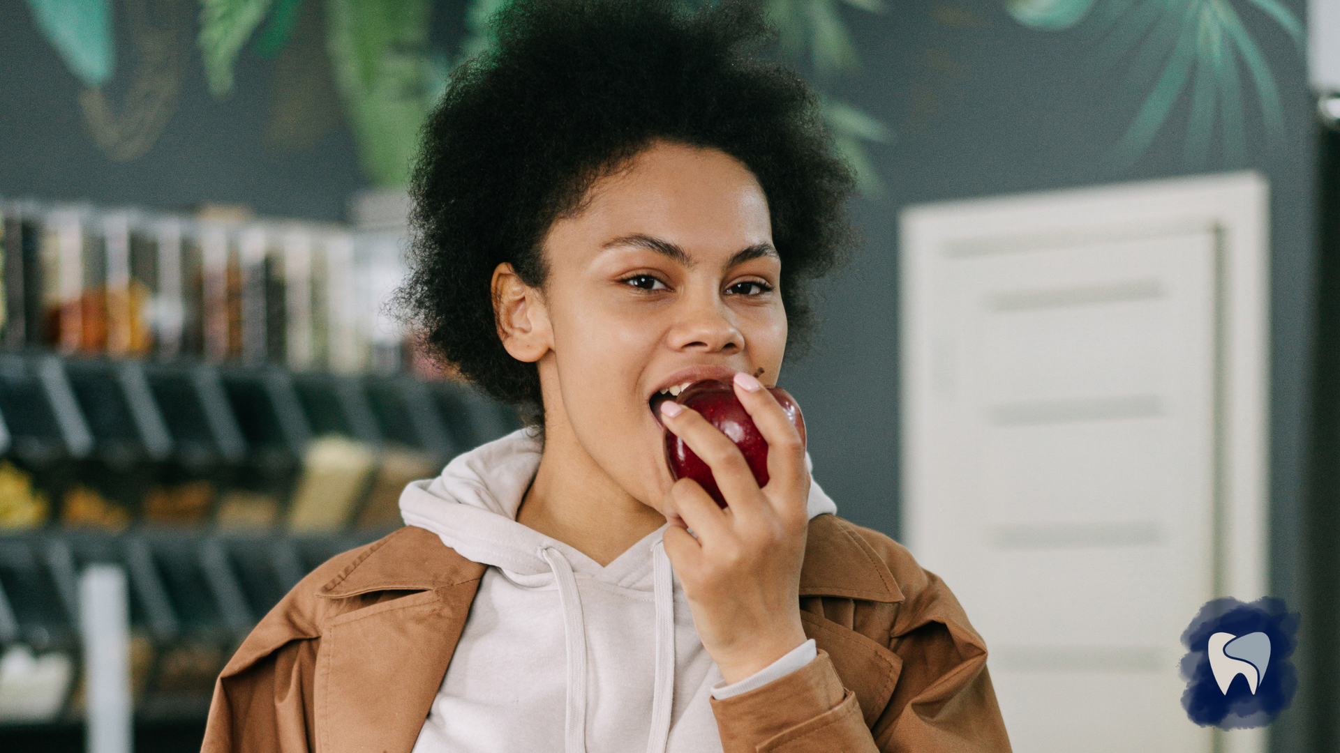 A woman is eating an apple in a restaurant.