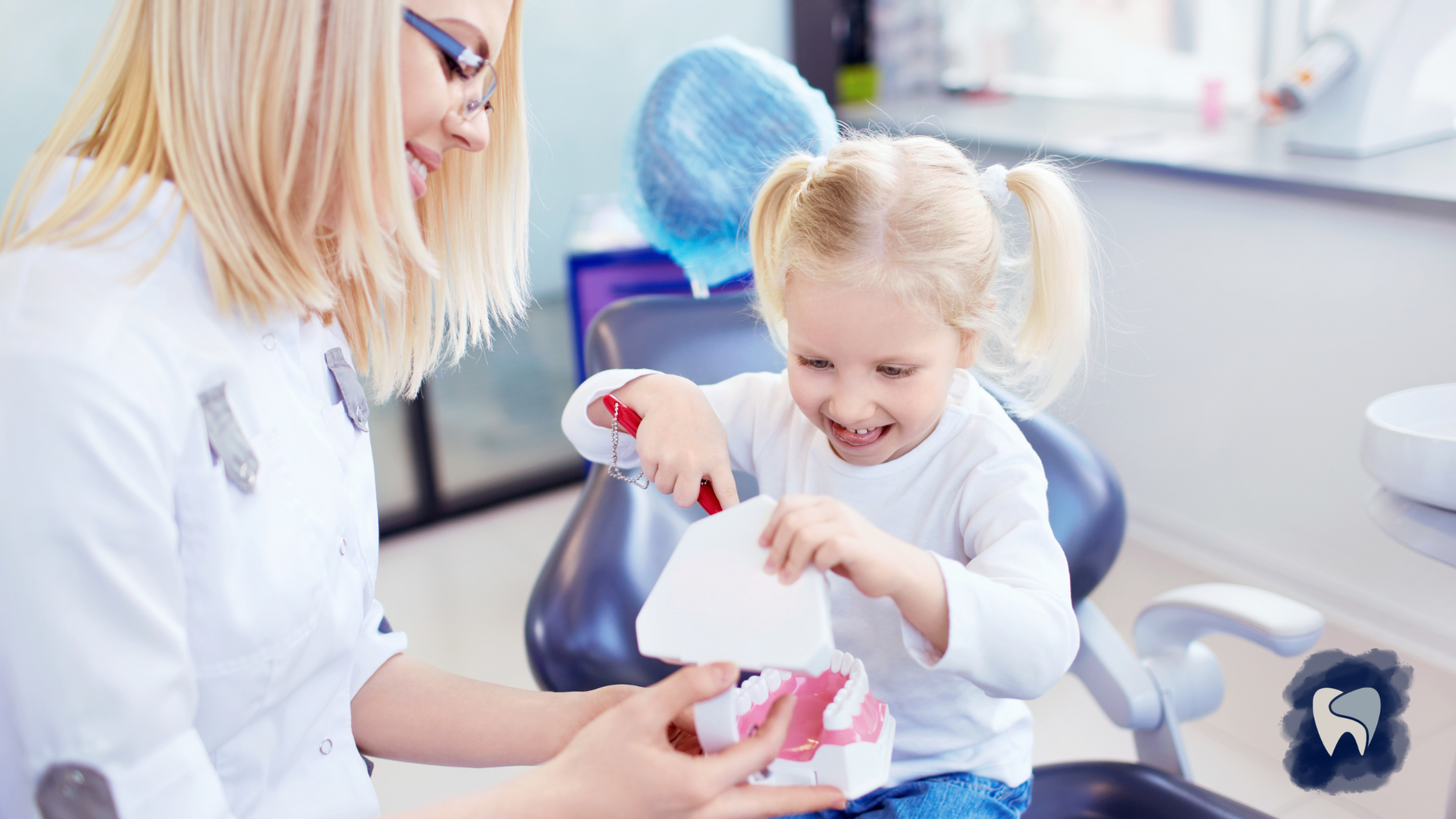 A little girl is sitting in a dental chair with a dentist.