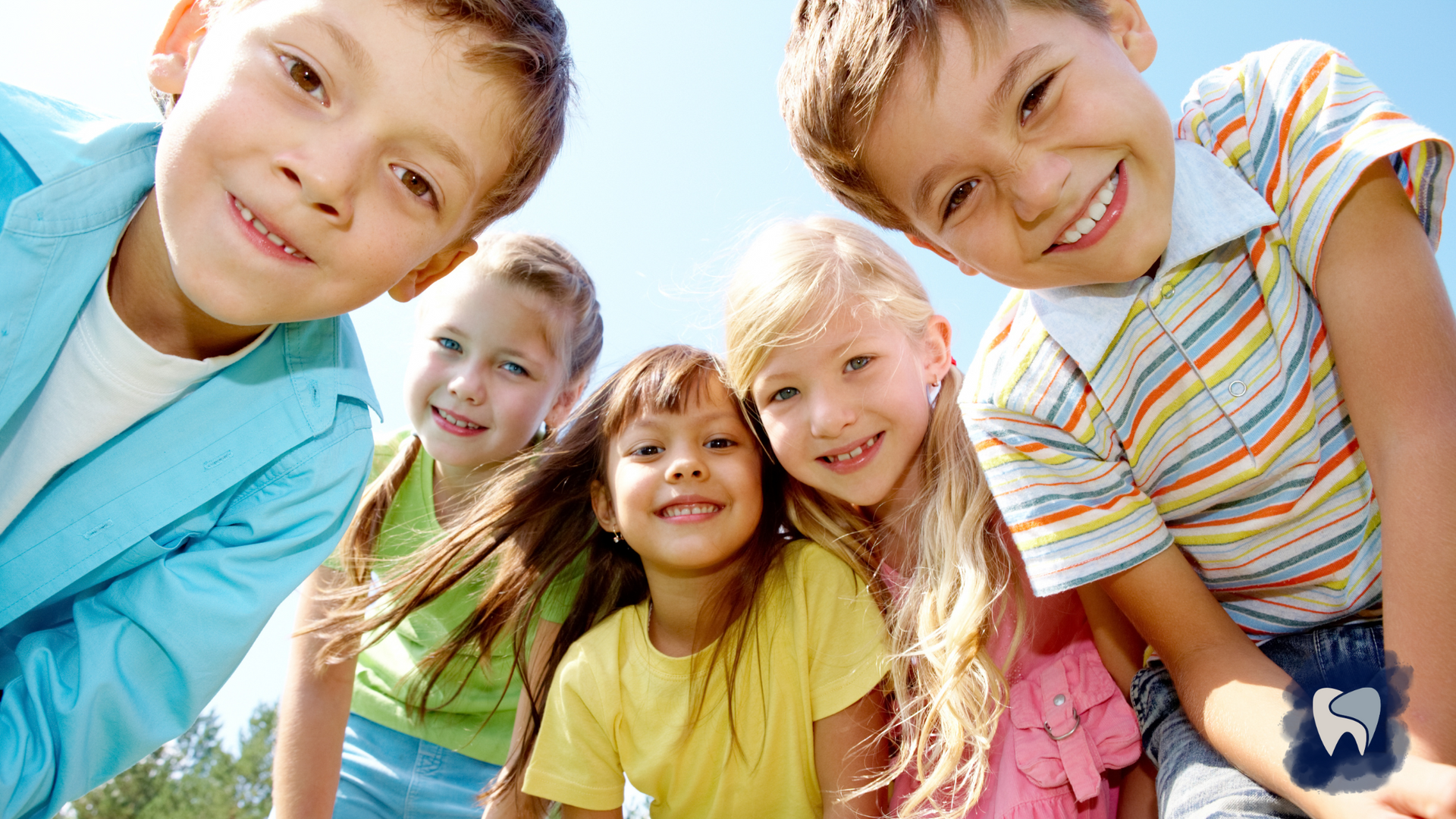 A group of children are posing for a picture together and smiling.