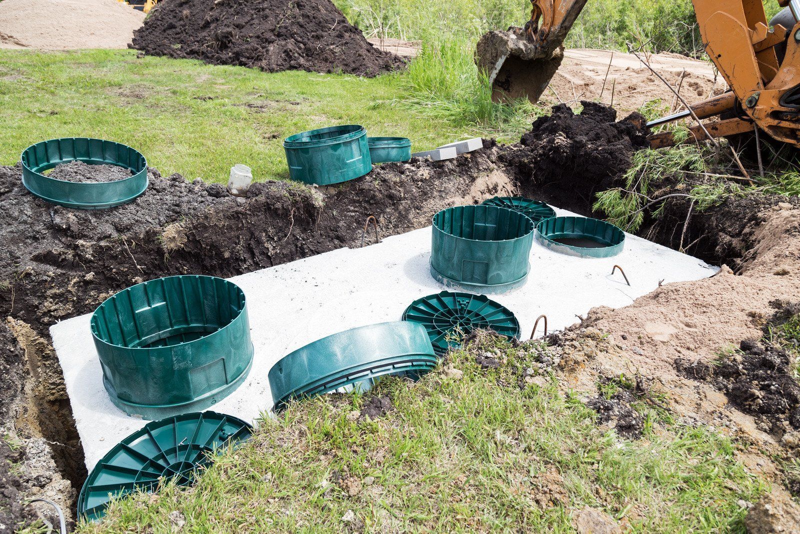 Stone outdoor pavilion with a dark wooden roof, built-in grill, and bench seating.