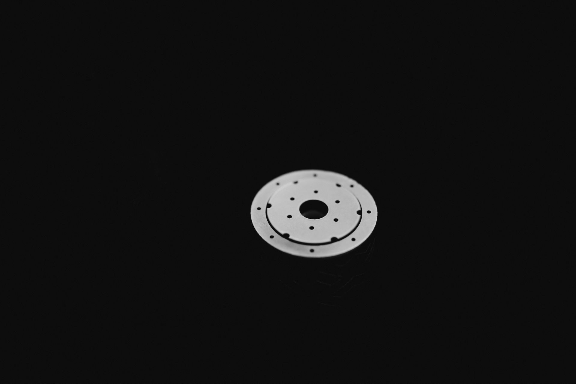 A white circle with a hole in the middle on a black background.