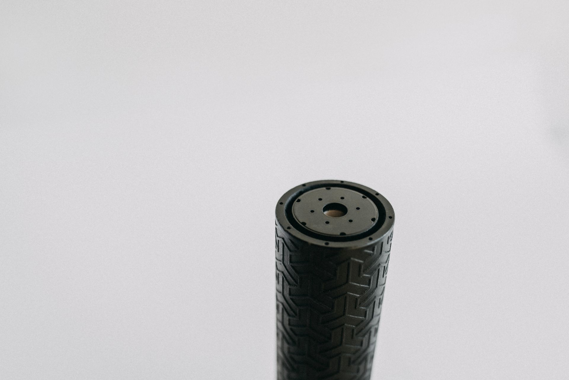 A black cylinder with a hole in the middle of it