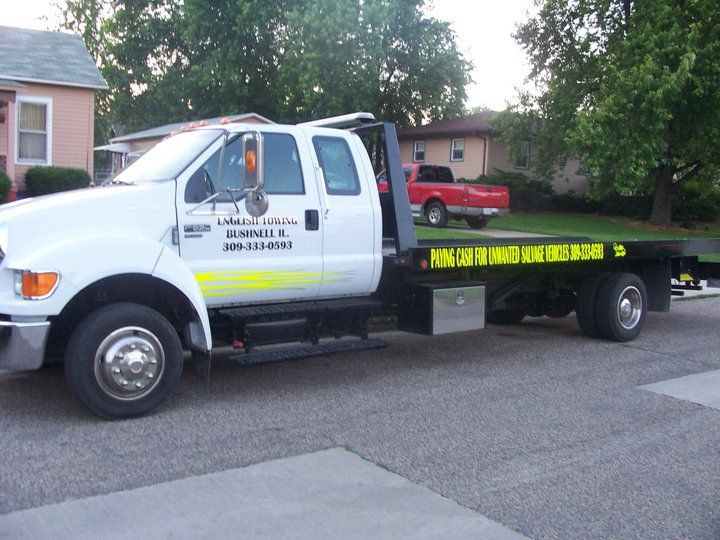 White tow truck parked on a residential street.