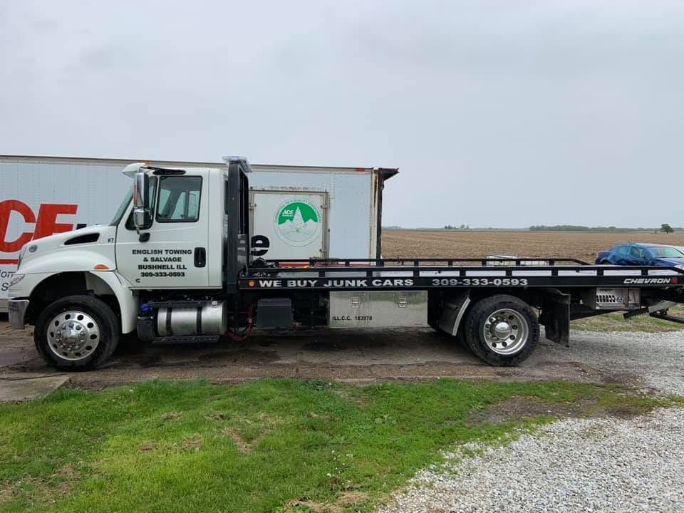 Tow truck parked in front of a building on a cloudy day.