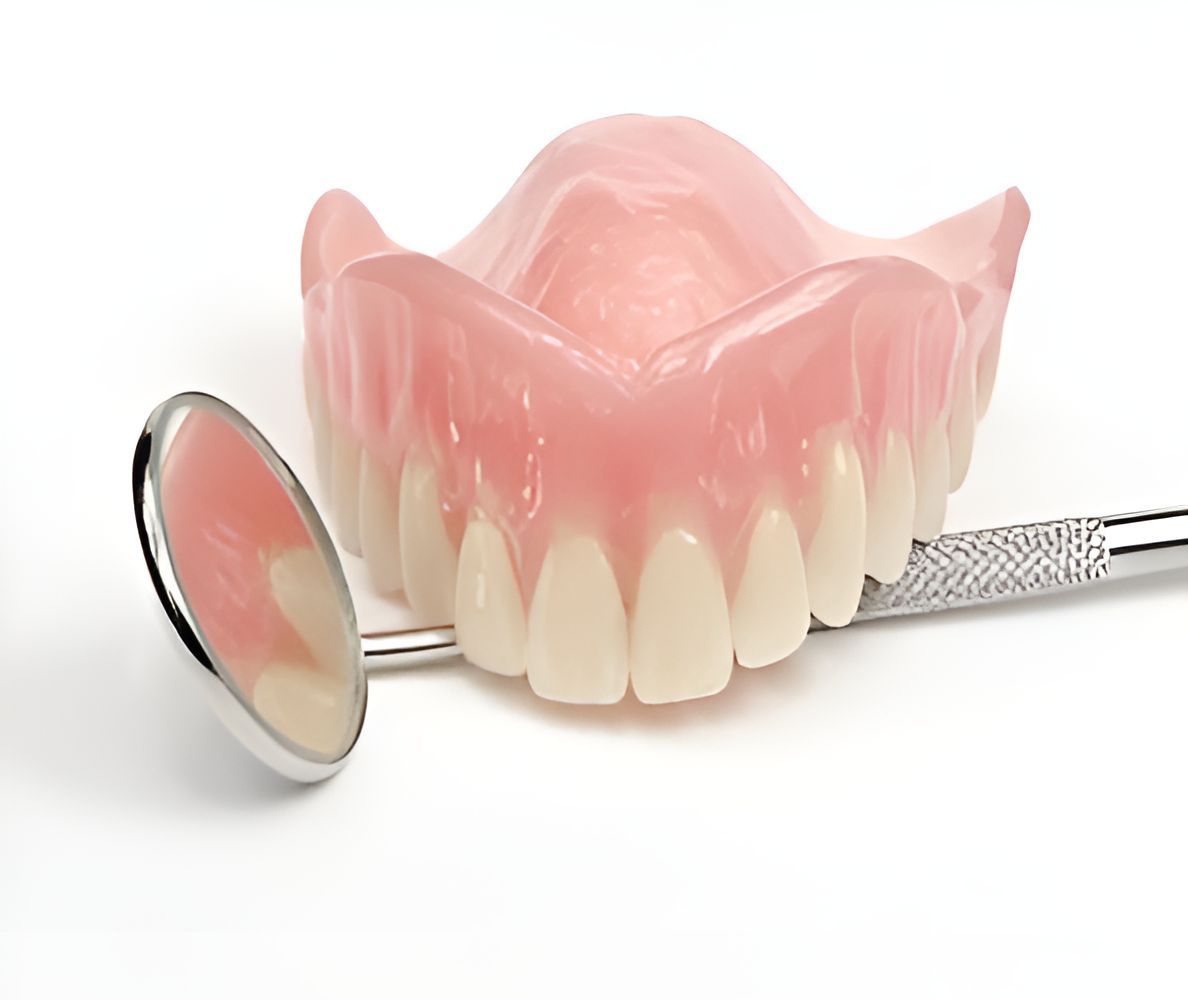 A Pair of Dentures and a Dental Mirror on a White Background — Maroochy Denture Clinic In Yandina, QLD