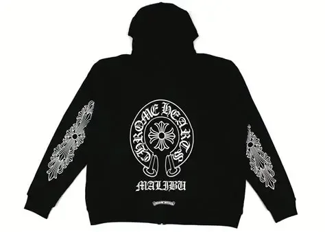 Black hoodie with white ornate design on sleeves and front.