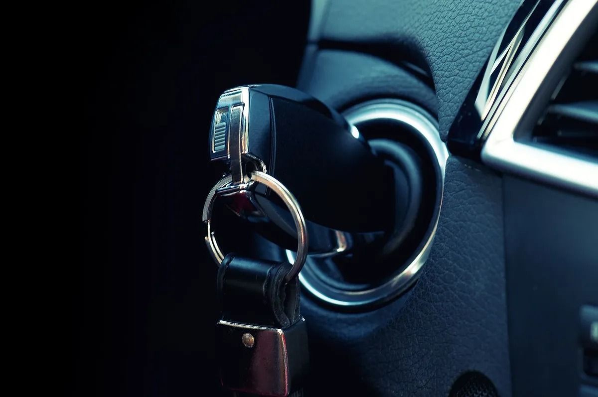 Car key in ignition of a car, with dashboard and steering wheel visible