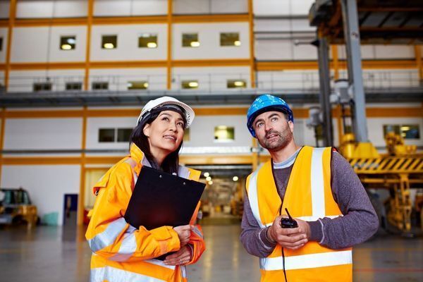 A man and a woman are standing next to each other in a warehouse.