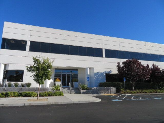 A large white building with a handicapped parking spot in front of it