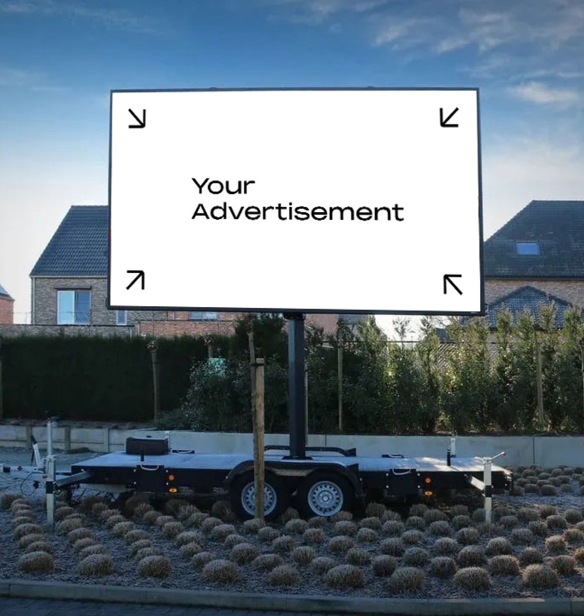 Billboardtrailer met lege advertentieruimte, buiten. Huizen en struiken op de achtergrond.