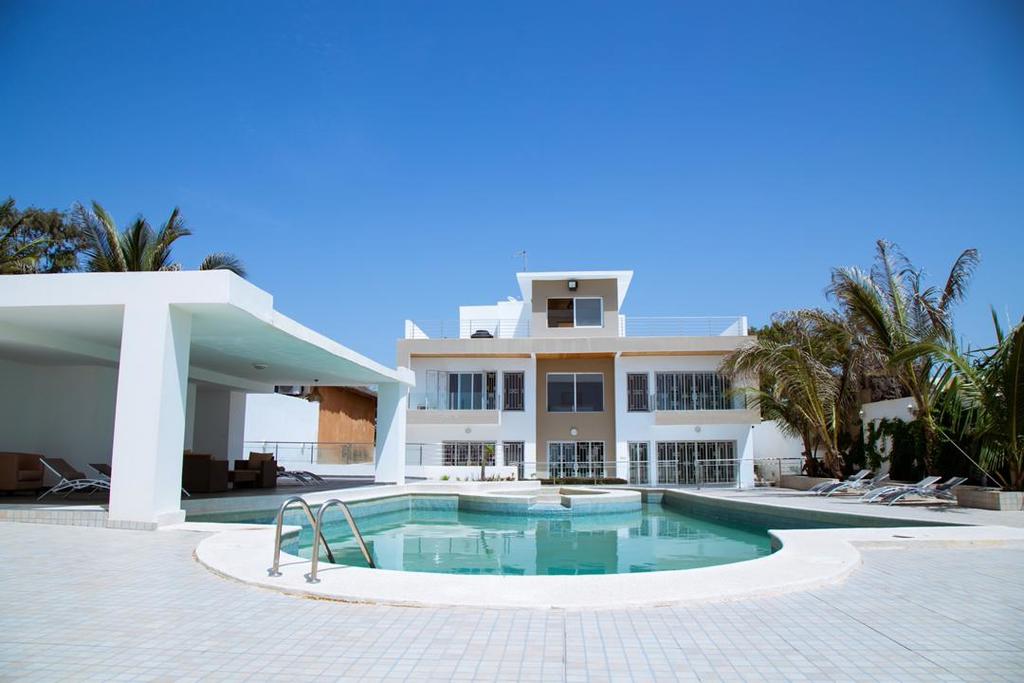 Une grande maison blanche avec une piscine devant.