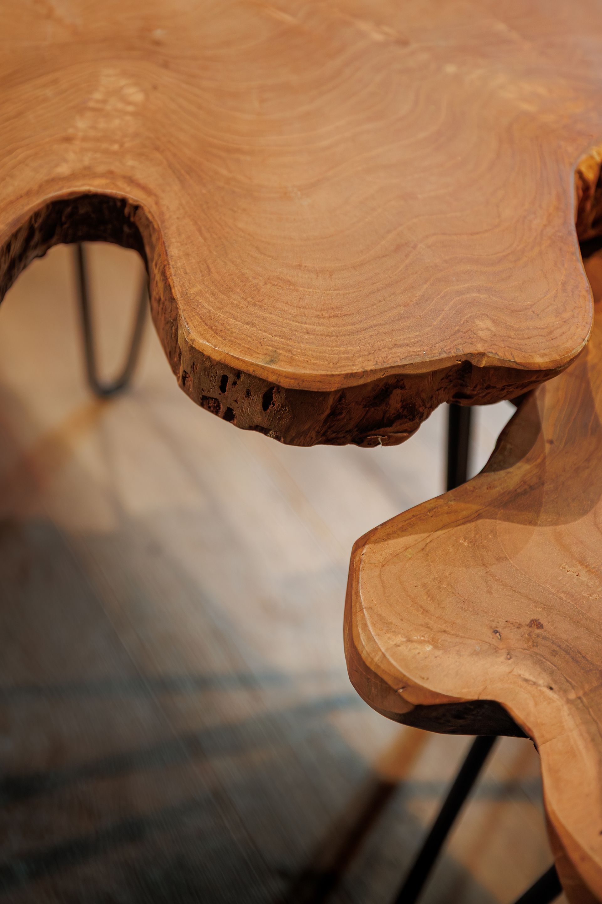 Close-up of natural wood table edges with visible grain and black metal legs
