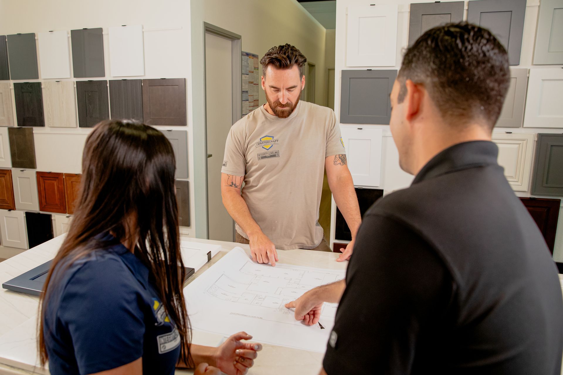 A group of people are standing around a table looking at a blueprint.