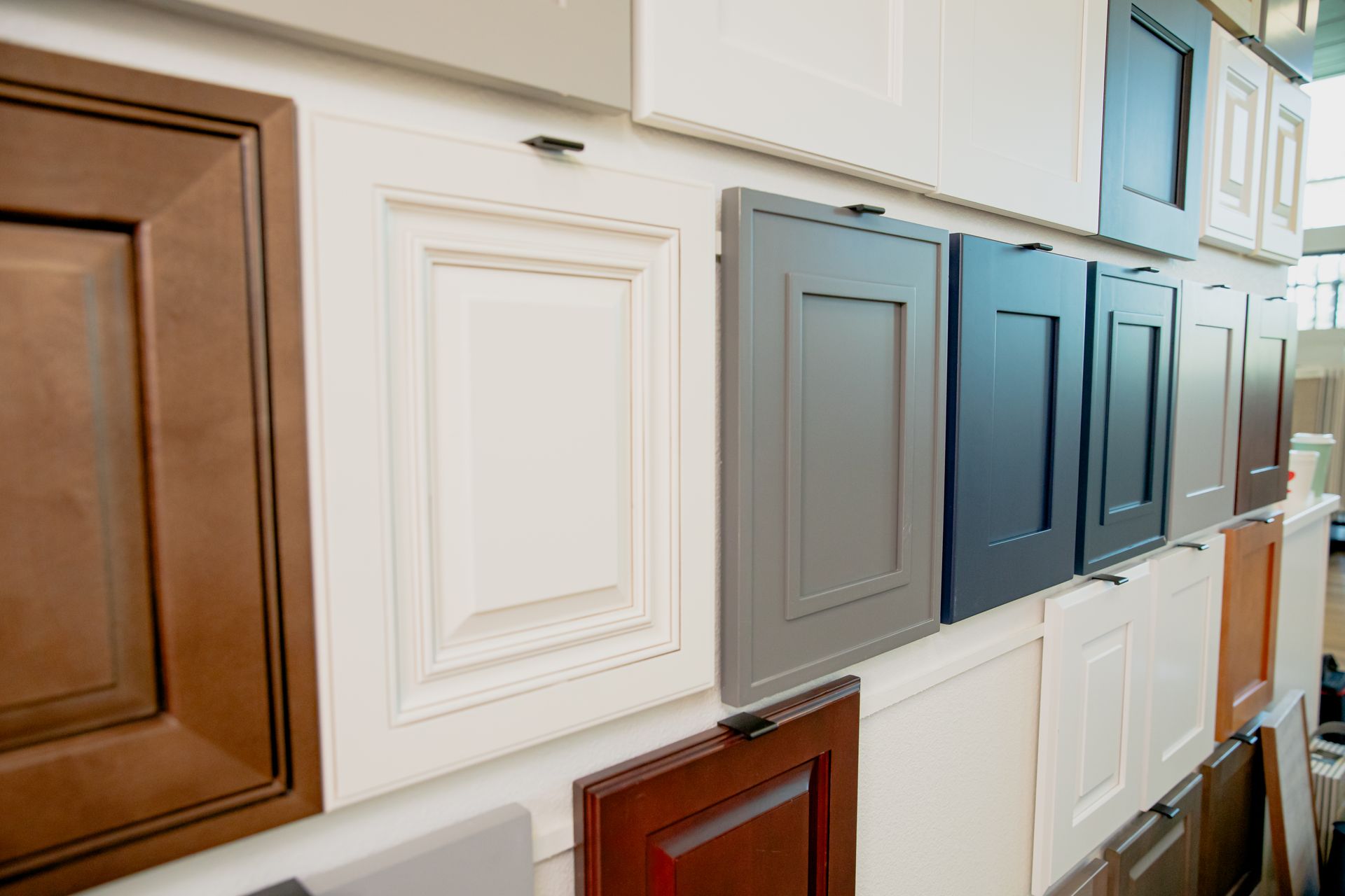 There are many different types of cabinet doors on the wall.