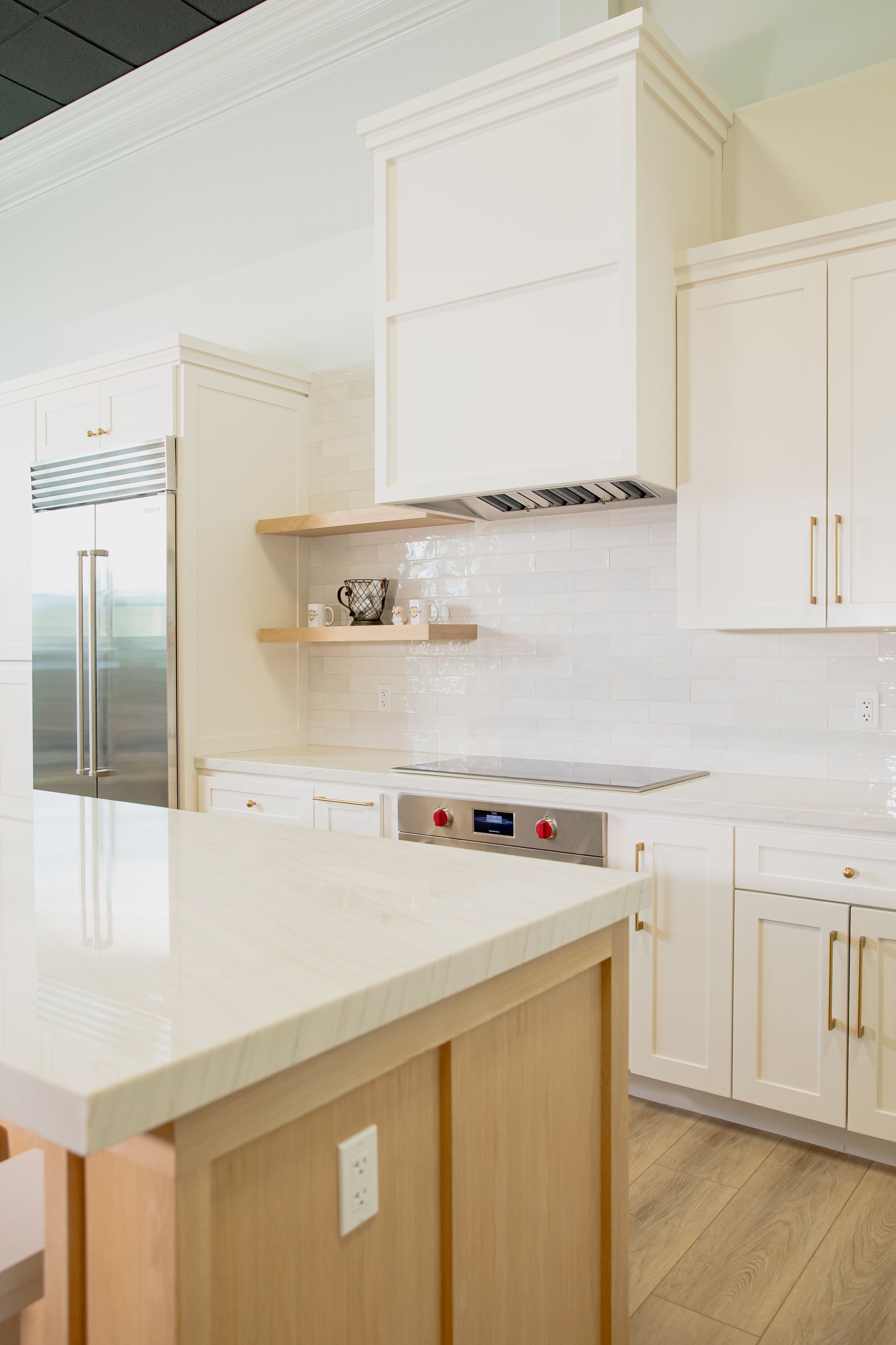A kitchen with white cabinets , a stove and a refrigerator.