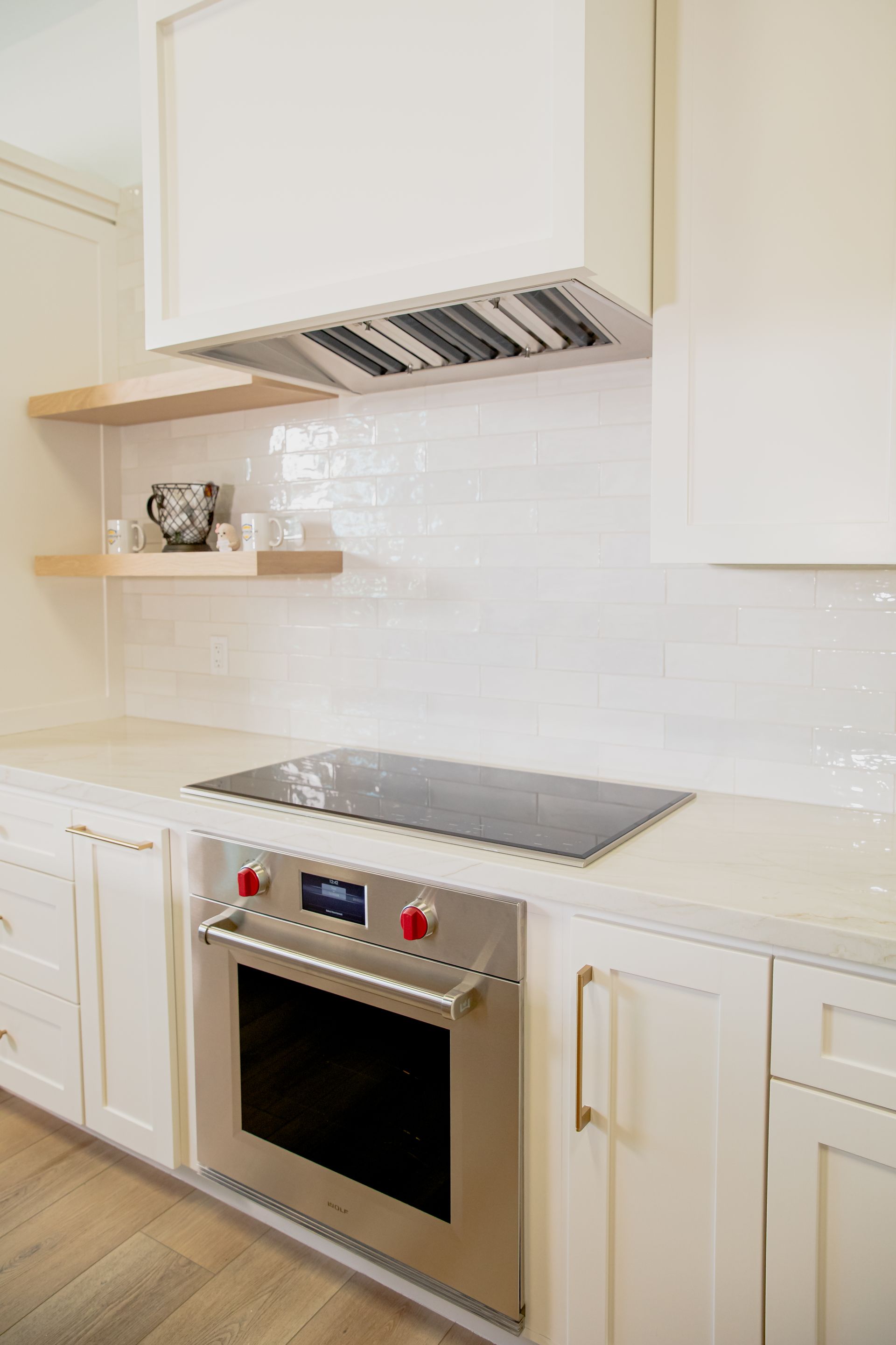 A kitchen with white cabinets , stainless steel appliances , and a stove top oven.