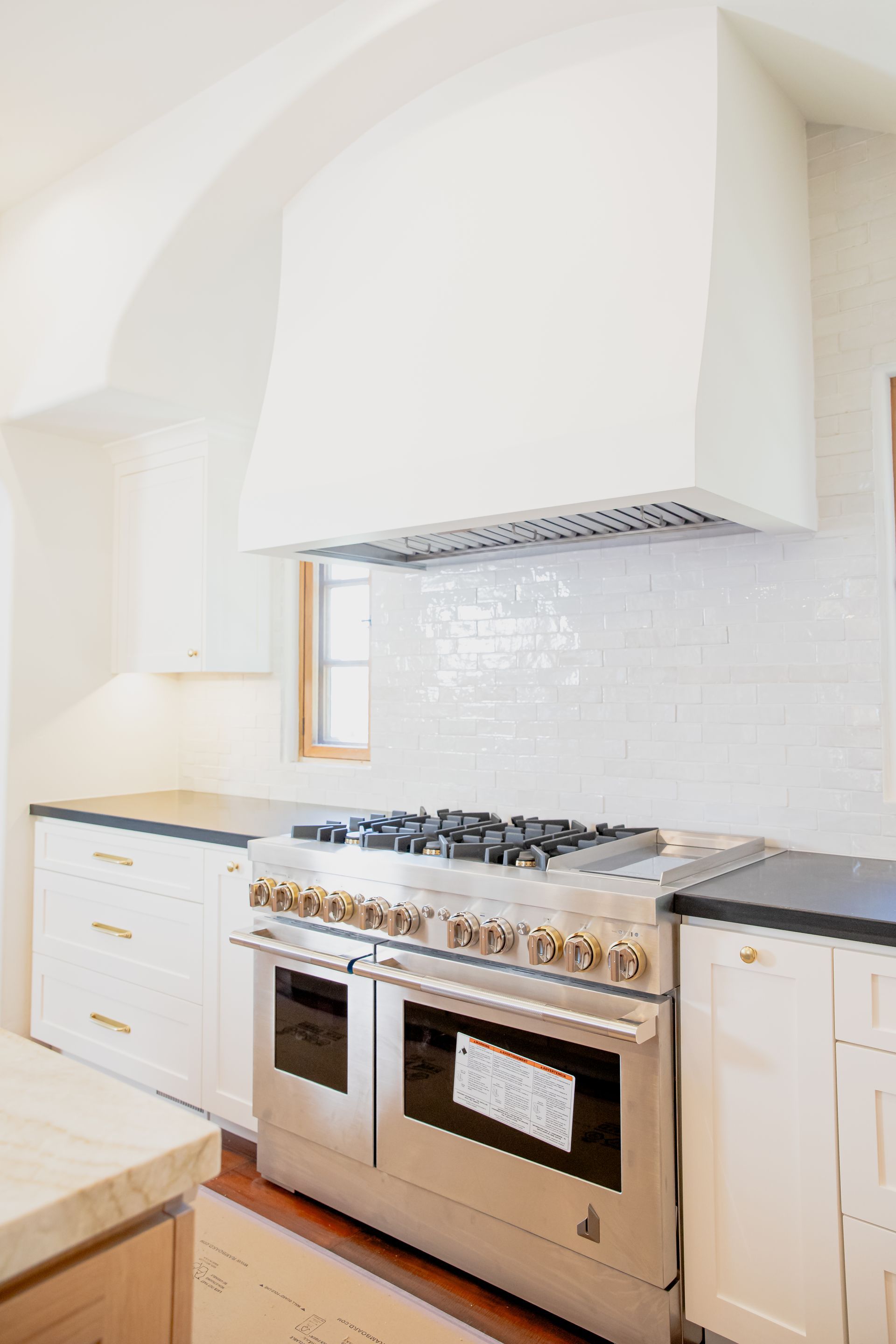 A kitchen with stainless steel appliances and white cabinets.