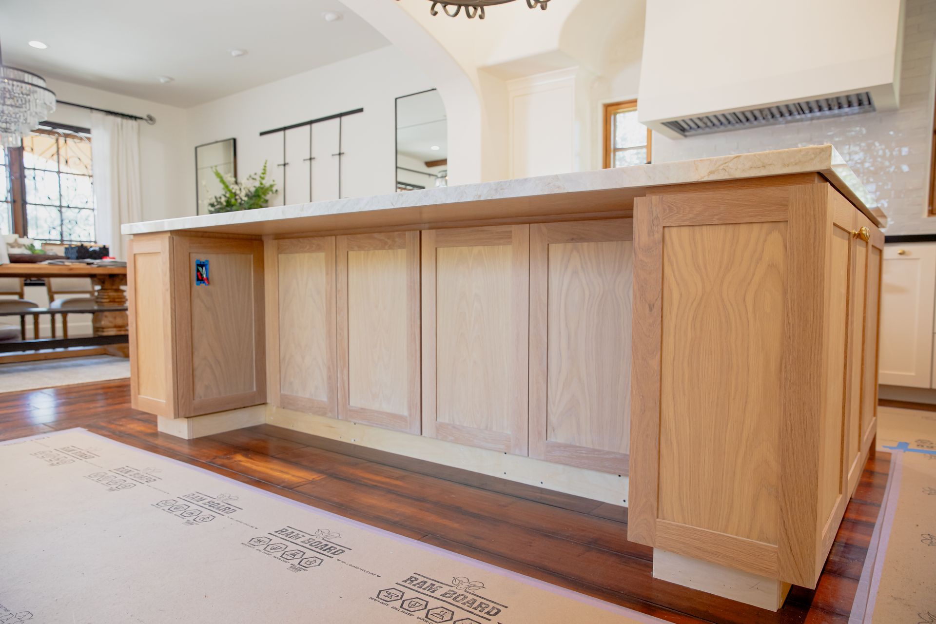 A kitchen with a large island and wooden cabinets.
