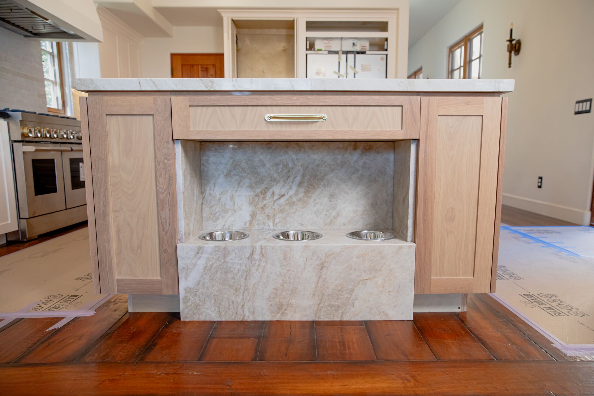 A kitchen with wooden cabinets and a marble counter top.