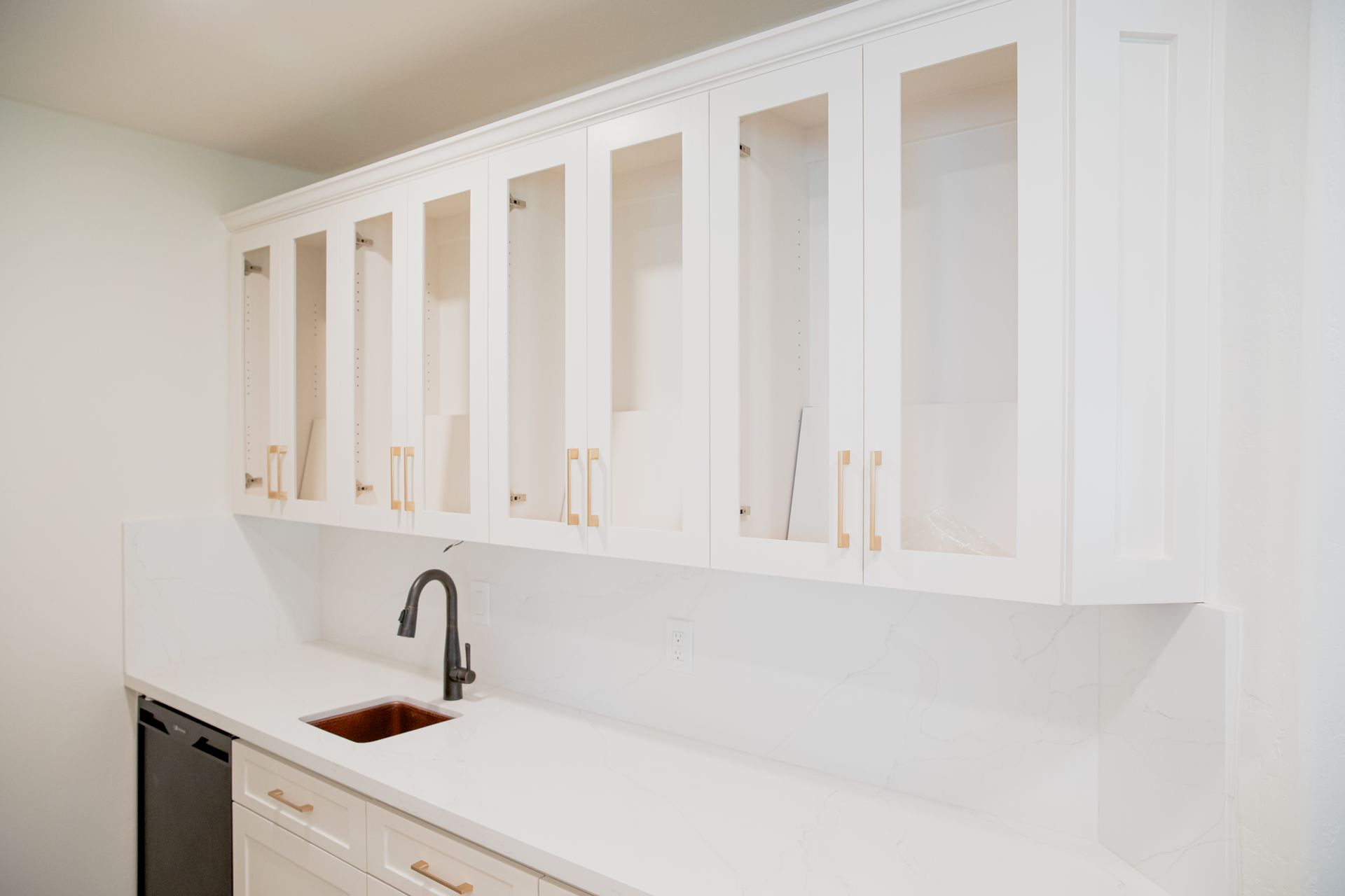 A kitchen with white cabinets and a sink.