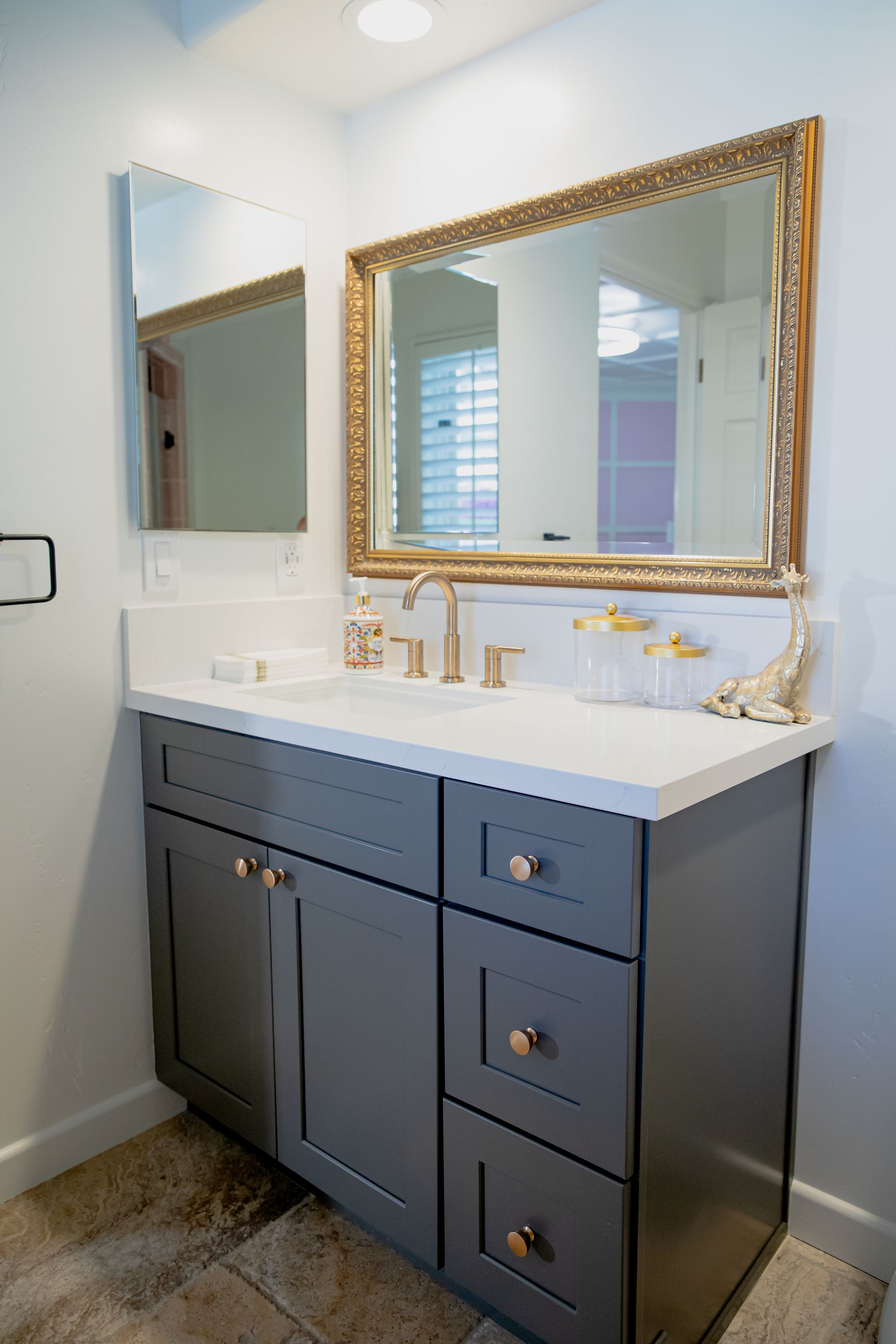 A bathroom with a sink , mirror and cabinets.