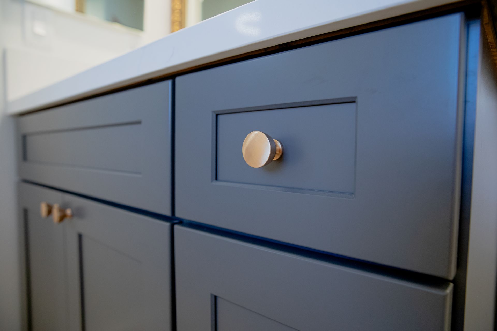 A close up of a kitchen cabinet with a brass knob.