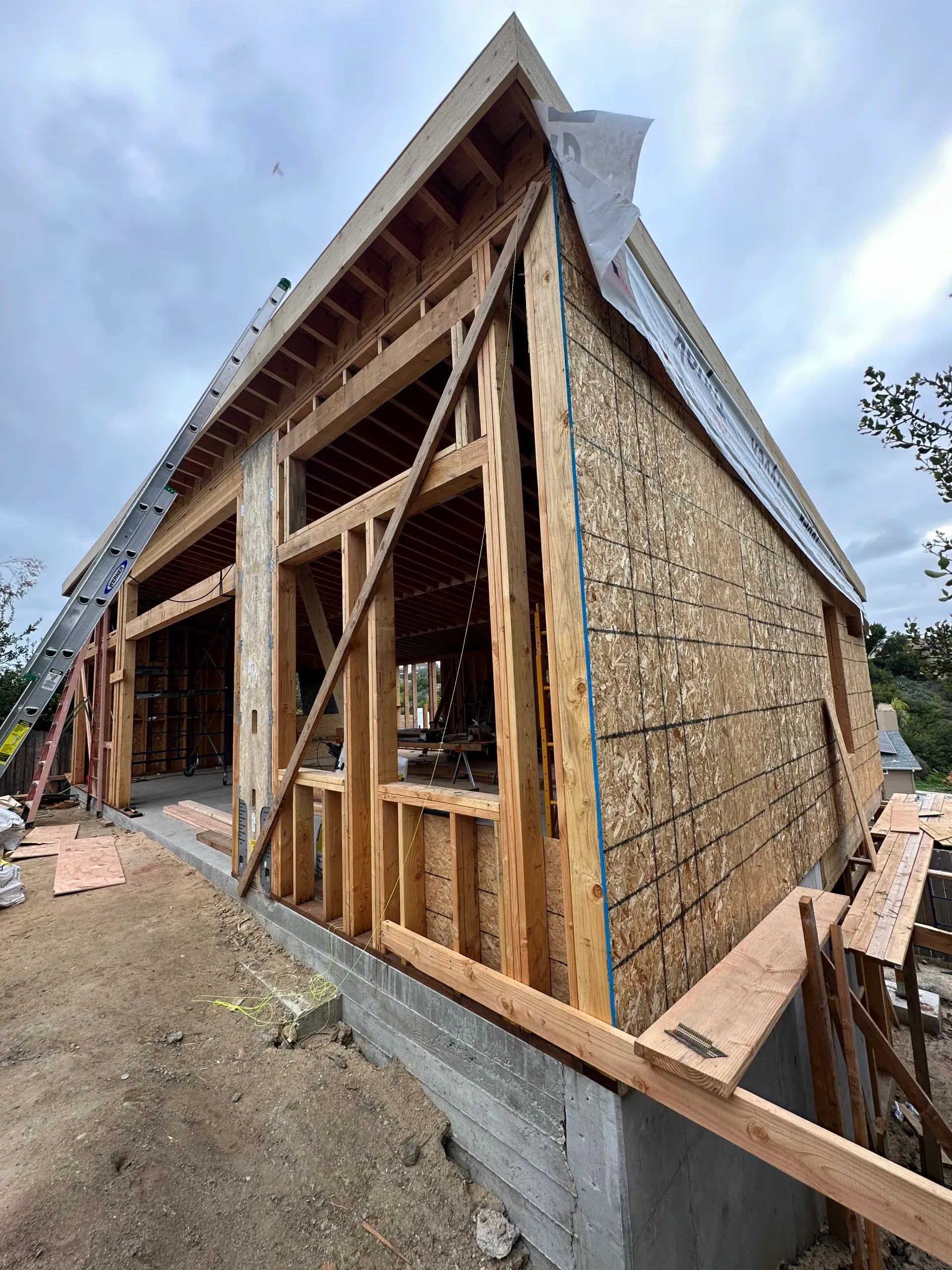A man is working on the roof of a house next to a hot tub.