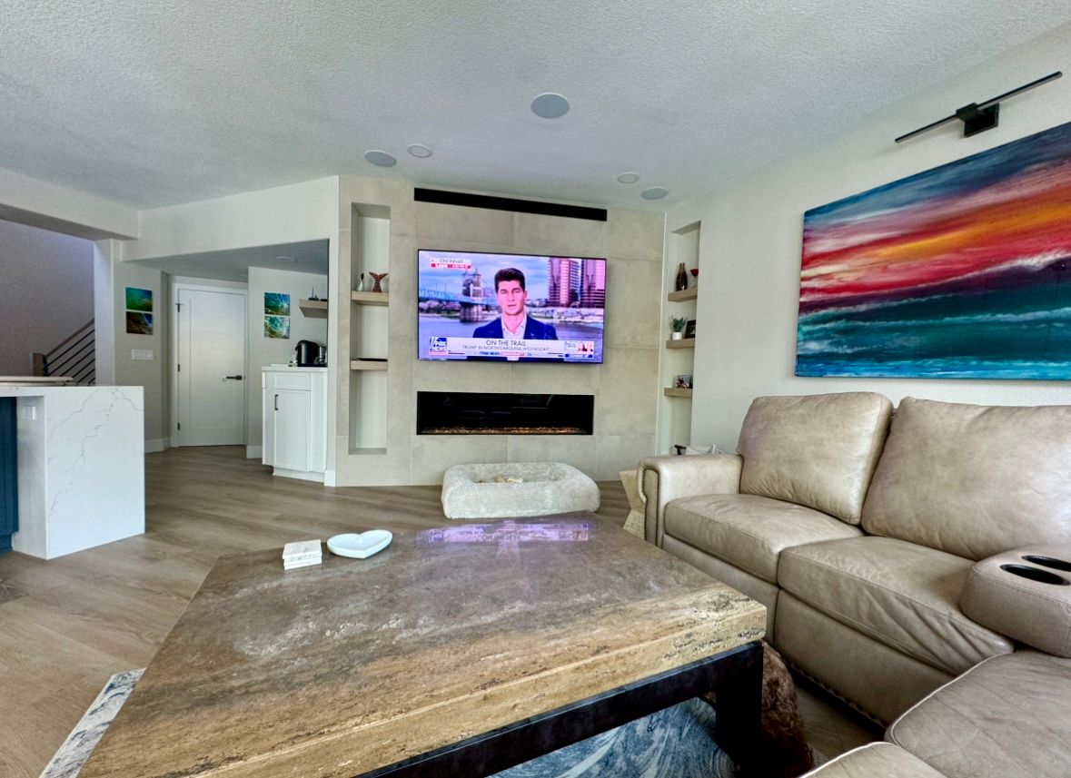 A living room with a couch and a flat screen tv on the wall.