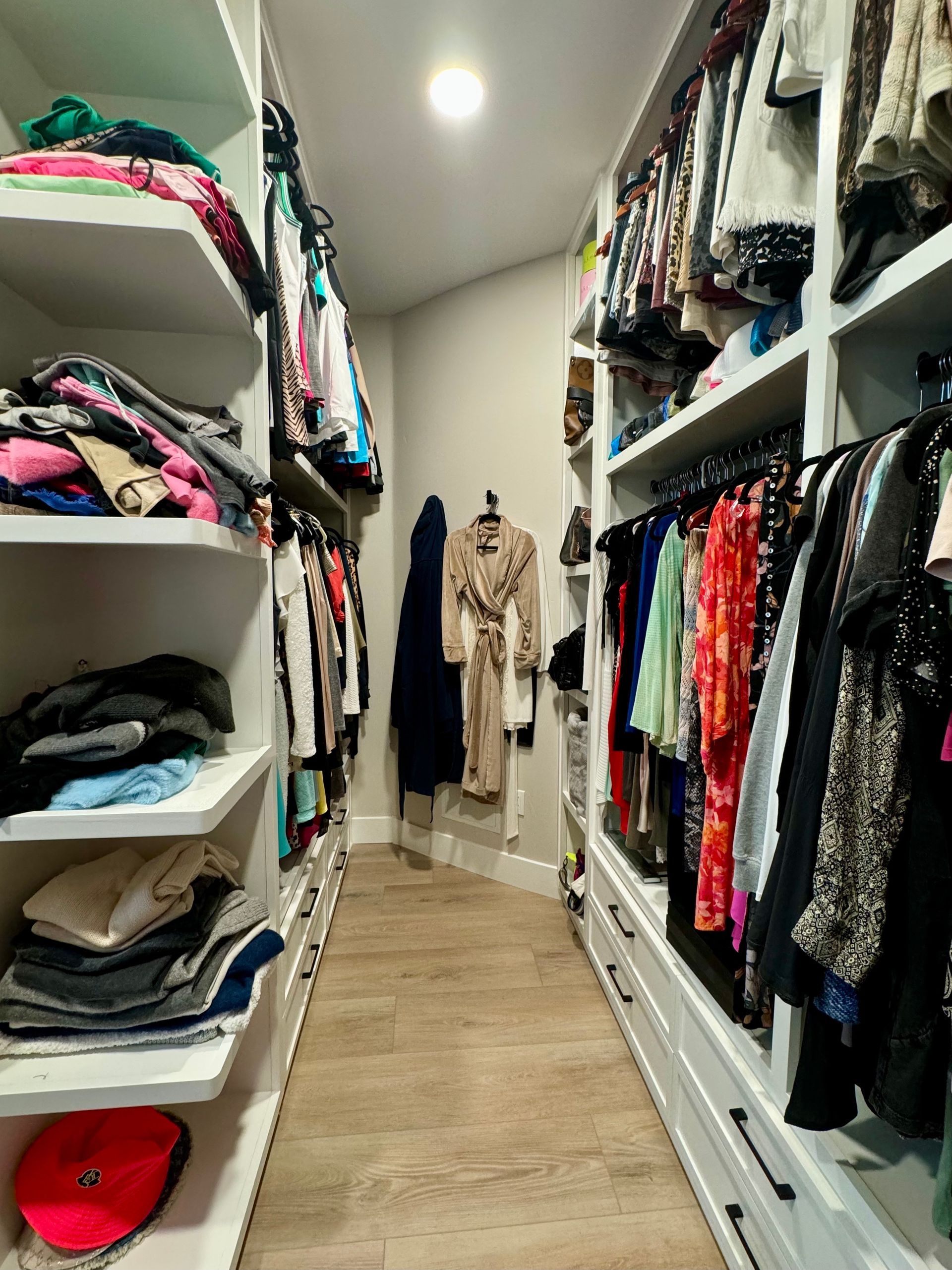 A walk in closet filled with lots of clothes.