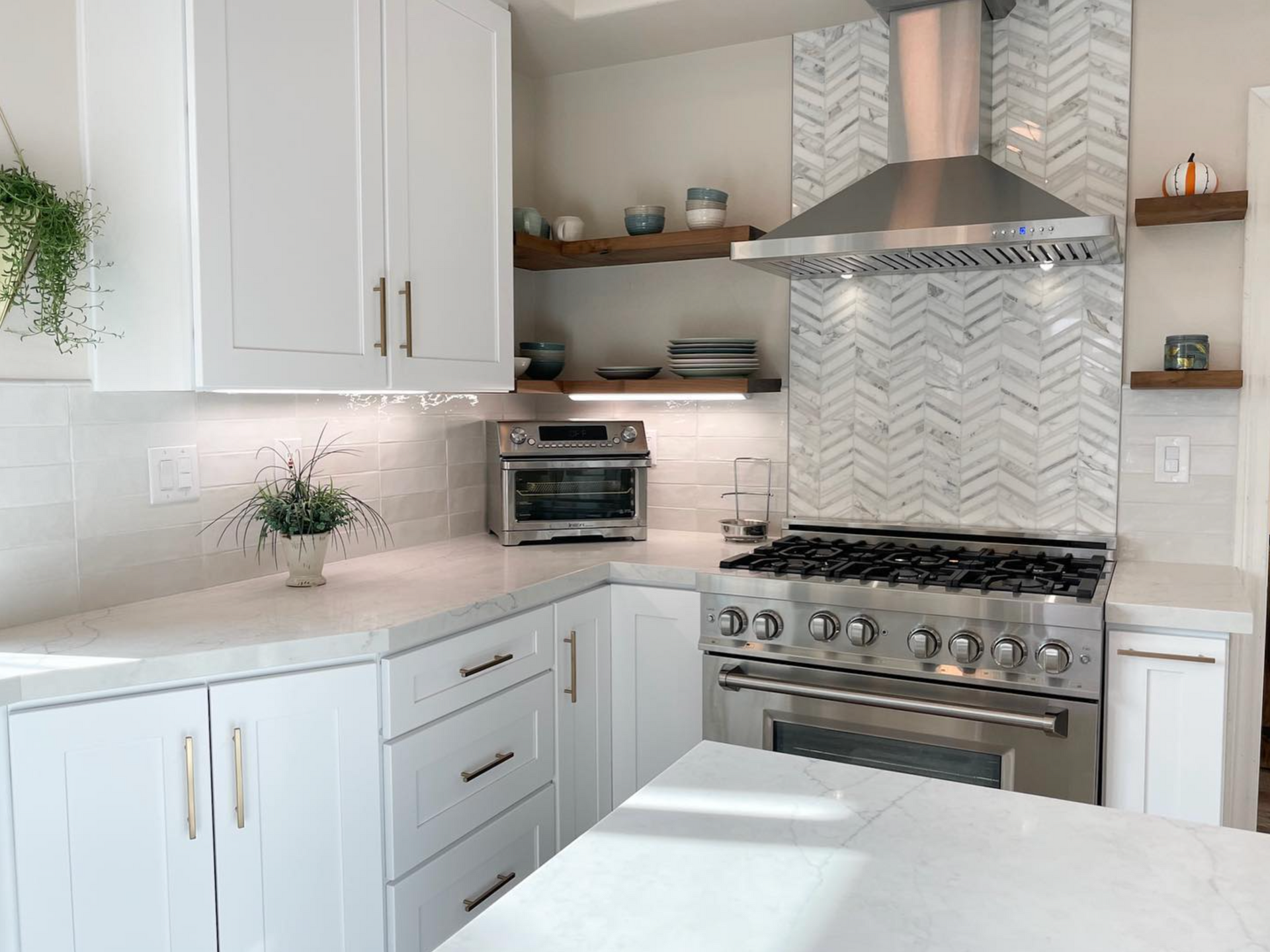 A kitchen with white cabinets , stainless steel appliances , and a stove.