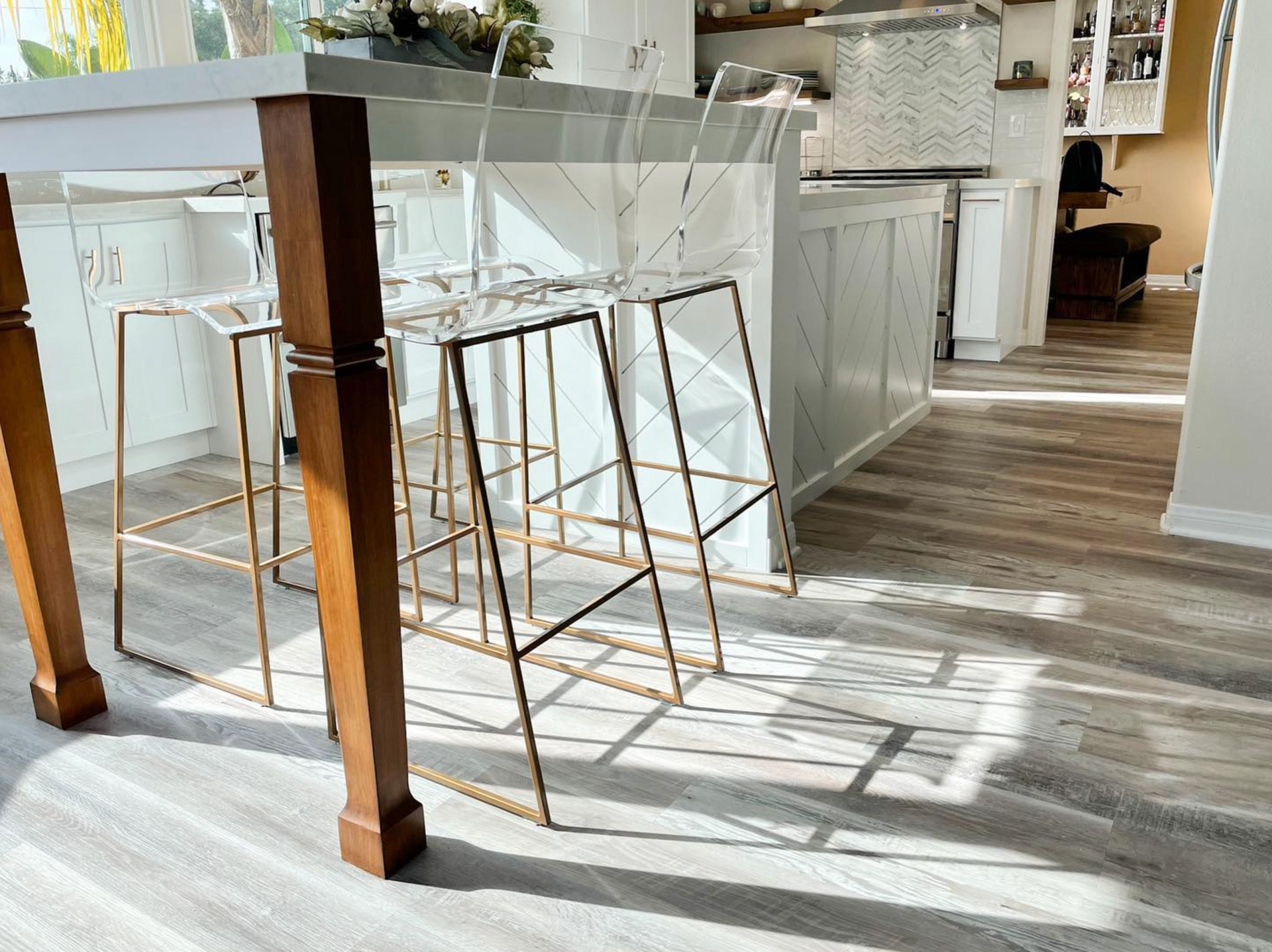 A kitchen with a table and stools in it.